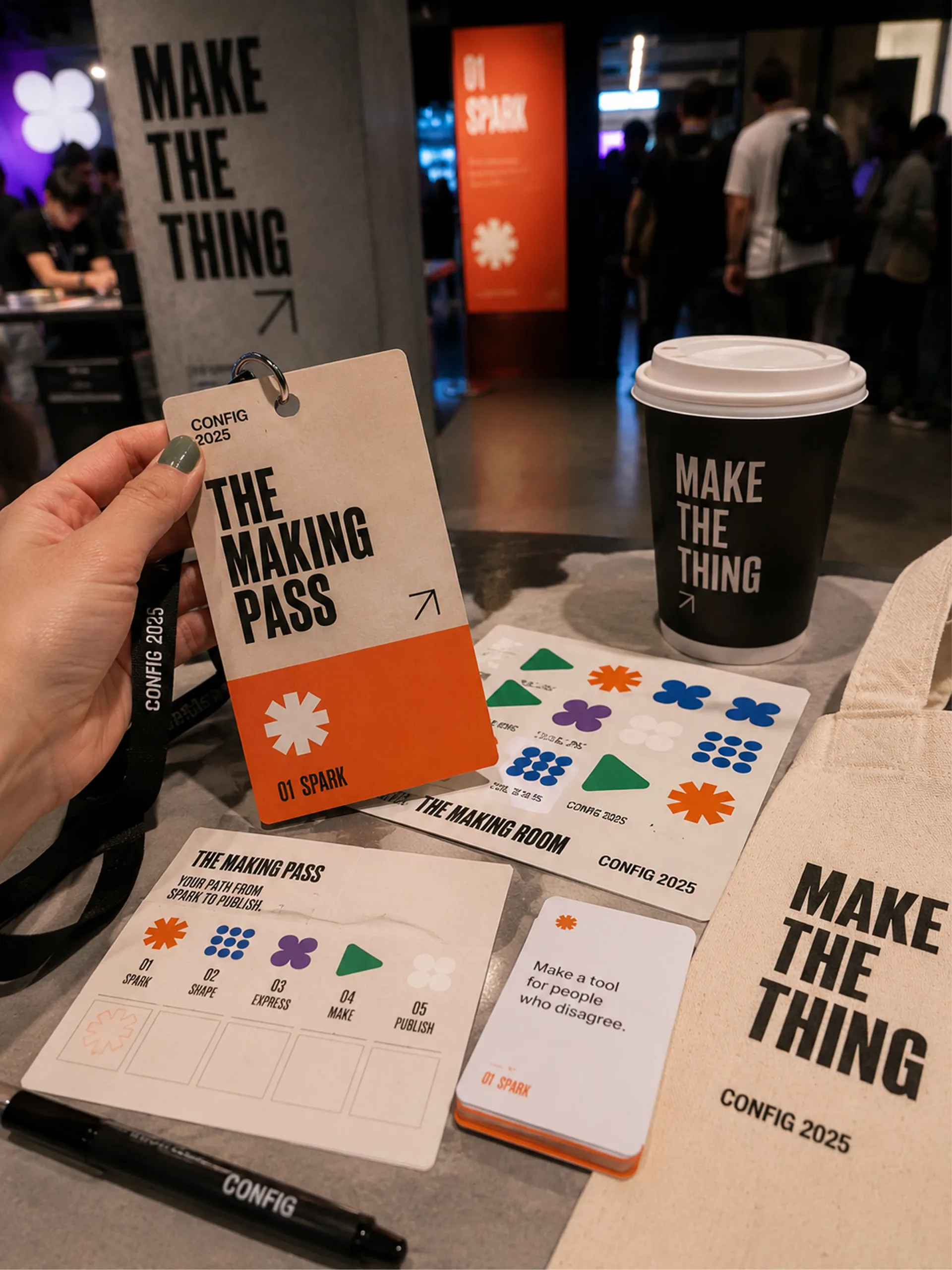 Config 2025 Making Room pass, coffee cup, guide, phone, and printed activity materials on a table